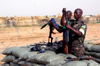 AU soldiers cleaning their guns in their Tawilla base, adjacent to Rwanda IDP camp, North Darfur.