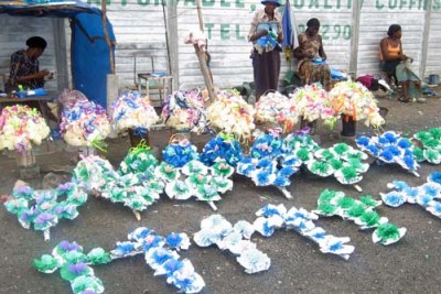 Vendors sell wreaths outside a funeral parlour.
