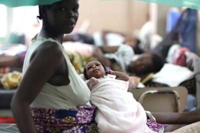 A patient holds her new born baby in a hospital ward in Freetown.