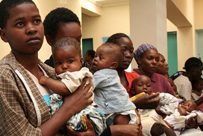 Mothers queue at a health centre for child immunisation.