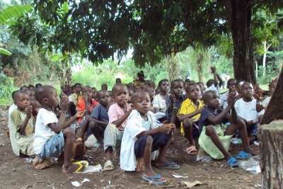 Refugee children from the Democratic Republic of Congo (DRC) learn in a forest clearing.