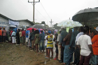 Liberians queue in the rain to cast their votes in 2011.