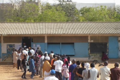 Voters line up outside a polling station.