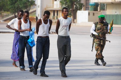 Four suspected members of Al Shabaab, the Islamic insurgent group, walk on the grounds of Mogadishu Stadium.
