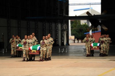 South African soldiers carry the coffins of their fallen colleagues who died during a battle with rebels in the Central African Republic to hearses at Waterkloof Air Force Base in Pretoria.