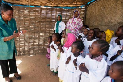 Des enfants accueillent en chantant la Secrétaire générale adjointe aux affaires humanitaires, Valérie Amos, dans le camp de Zamzam au Darfour