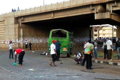 Bomb experts and plainclothes police officers gather at the scene of a bus explosion along the Thika super-highway in Nairobi.