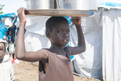 Un enfant portant de l’eau sur le site de Tomping de l’ONU.