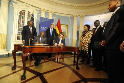 Ghana President John Dramani Mahama and U.S. Secretary of State John Kerry look on as Seth Terkper, Ghana's Minister of Finance and Economic Planning and MCC CEO Dana J. Hyde complete signing of the Ghana Power Compact in the Treaty Room at the State Department.