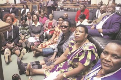 National Assembly members sit on the floor in protest of the abuse of Zimbabwean women in Kuwait.