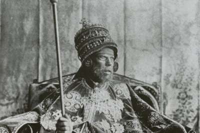 Emperor Menelik II photographed on the throne in coronation garb.