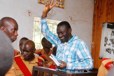 Kizza Besigye flashes the FDC symbol at the Kasangati Magistrate’s Court in Wakiso District (file photo)