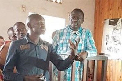Kizza Besigye looks at  policeman Brian Omwito as he makes his submissions, a video evidence meant to pin him for disobeying lawful orders.