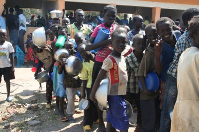 Some of the South Sudanese refugee children line up for food after arriving at Rhino Settlement Camp in Arua District in July this year
