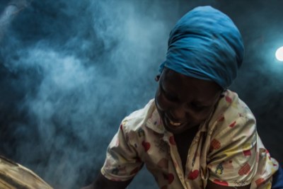 Catherine Wambu uses her M-KOPA solar powered light to cook at night.