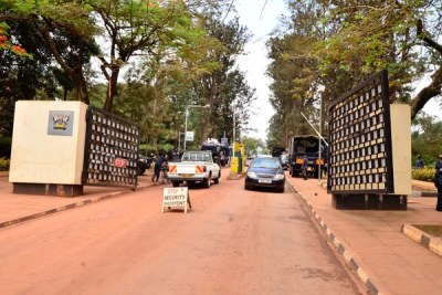Vehicles move in and out of Makerere University main gate.