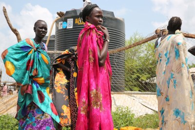 Des femmes déplacées par des combats à Juba, au Soudan du Sud, attendent de remplir des containers d’eau.