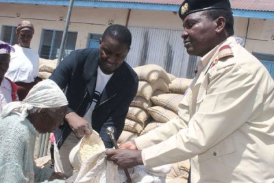Margaret Njeri in Laikipia East receives relief food from Devolution Cabinet Secretary Mwangi Kiunjuri (center) and County Commissioner Onesmus Musyoki (file photo).