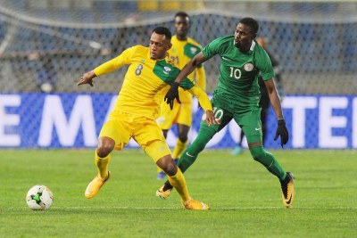Amavubi's Ali Niyonzima (left) holds off a Nigerian player during their Group C match at Grand Stade de Tanger.
