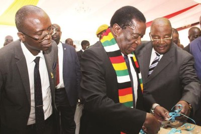 President Emmerson Mnangagwa, flanked by Vice President Kembo Mohadi, right,  and Home Affairs and Culture Minister Obert Mpofu officially opens a box of Cabinet documents which were repatriated from Rhodes University while Director National Archives Ivan Munhamo Murambiwa looks on at State House in Harare.