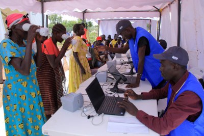 Verification. World Food Programme officials register refugees using a biometric verification system at Imvepi Refugee Settlement Camp in Arua District.