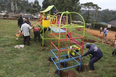 Workmen install equipment at a children’s playground rehabilitated from an illegal dumping site in a section of Kangemi area cemetery.