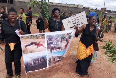 Women protest, holding up a poster with images of atrocities committed in an ongoing conflict between government forces and armed separatists, in Bamenda, Cameroon, September 7, 2018.