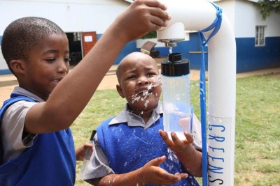 Children fill up their bottles of water from a GreenSource tap in South Africa on 22 April 2019.