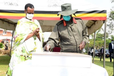 President Museveni (right), accompanied by his wife Janet Museveni, signs a book to mark the Tarehe Sita day.
