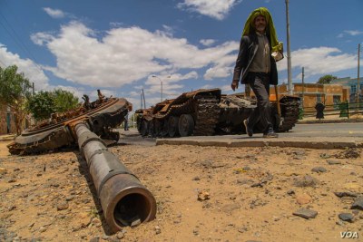 A man passes by a destroyed tank on the main street of Edaga Hamus, in the Tigray region, in Ethiopia, on June 5, 2021.