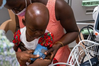 Une fillette de deux ans atteinte d'un cancer se fait prendre ses signes vitaux par une infirmière dans un hôpital du Ghana.