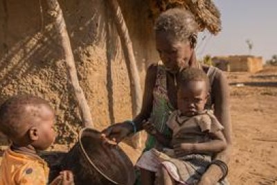 Une mère donne de la bouillie de sorgho à ses enfants. Un nombre croissant d'enfants du nord du Bahr el Ghazal et de Warrap au Soudan du Sud ne prennent qu'un seul repas par jour.