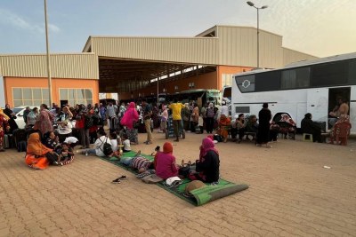 People fleeing conflict in Sudan wait at a bus station in Khartoum.